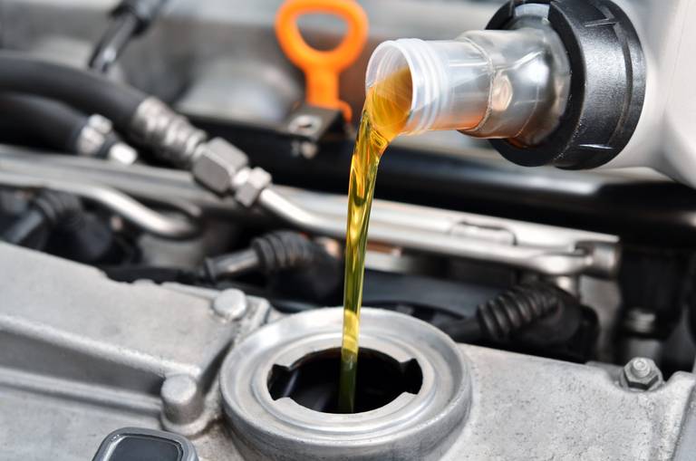 Ölwechsel in einem automotor ein automechaniker gießt motoröl